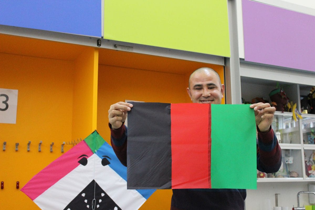 Ahmadzia holds up a small kite in the Afghanistan flag colours