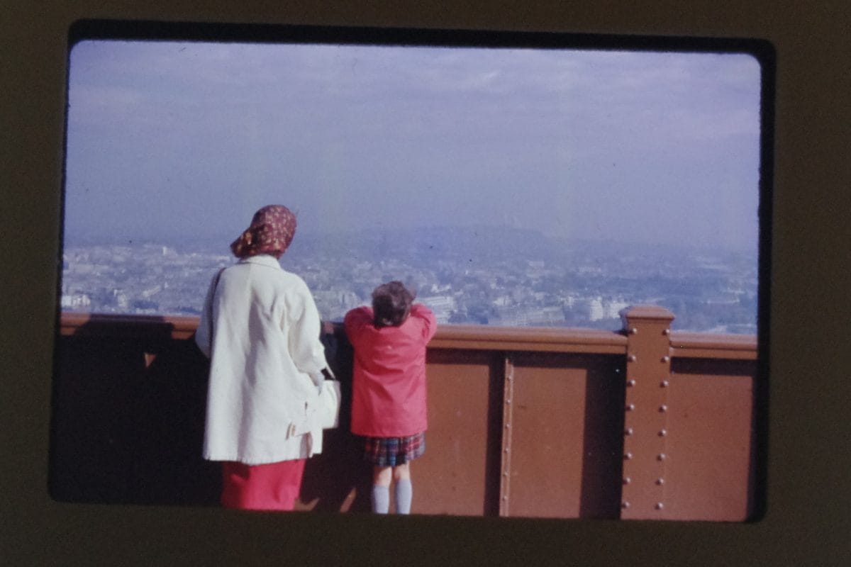 Photograph of woman and child looking at at city horizon