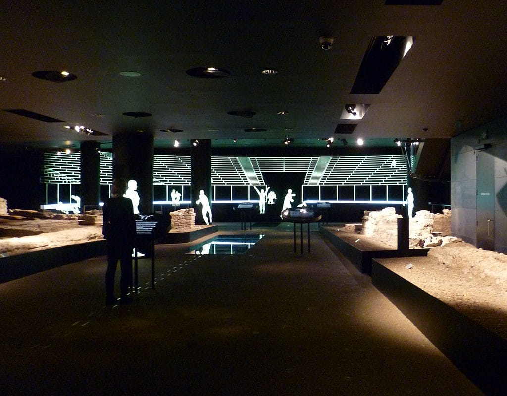 Dark room with lit up figures across the back of room.