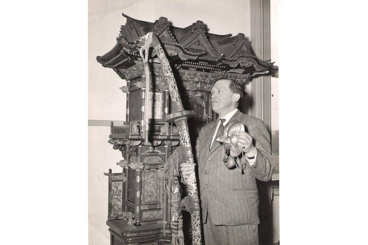 Man standing with sword and other Japanese objects