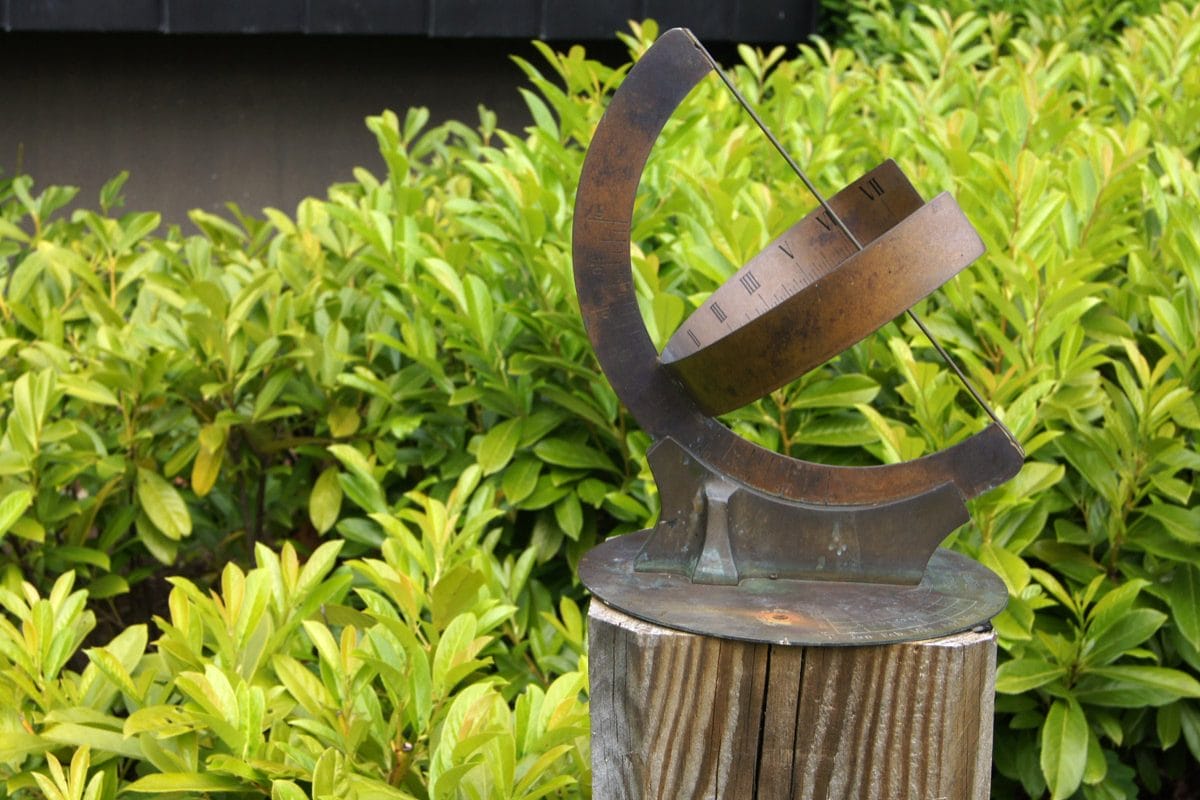 A metal curved sundial in a garden