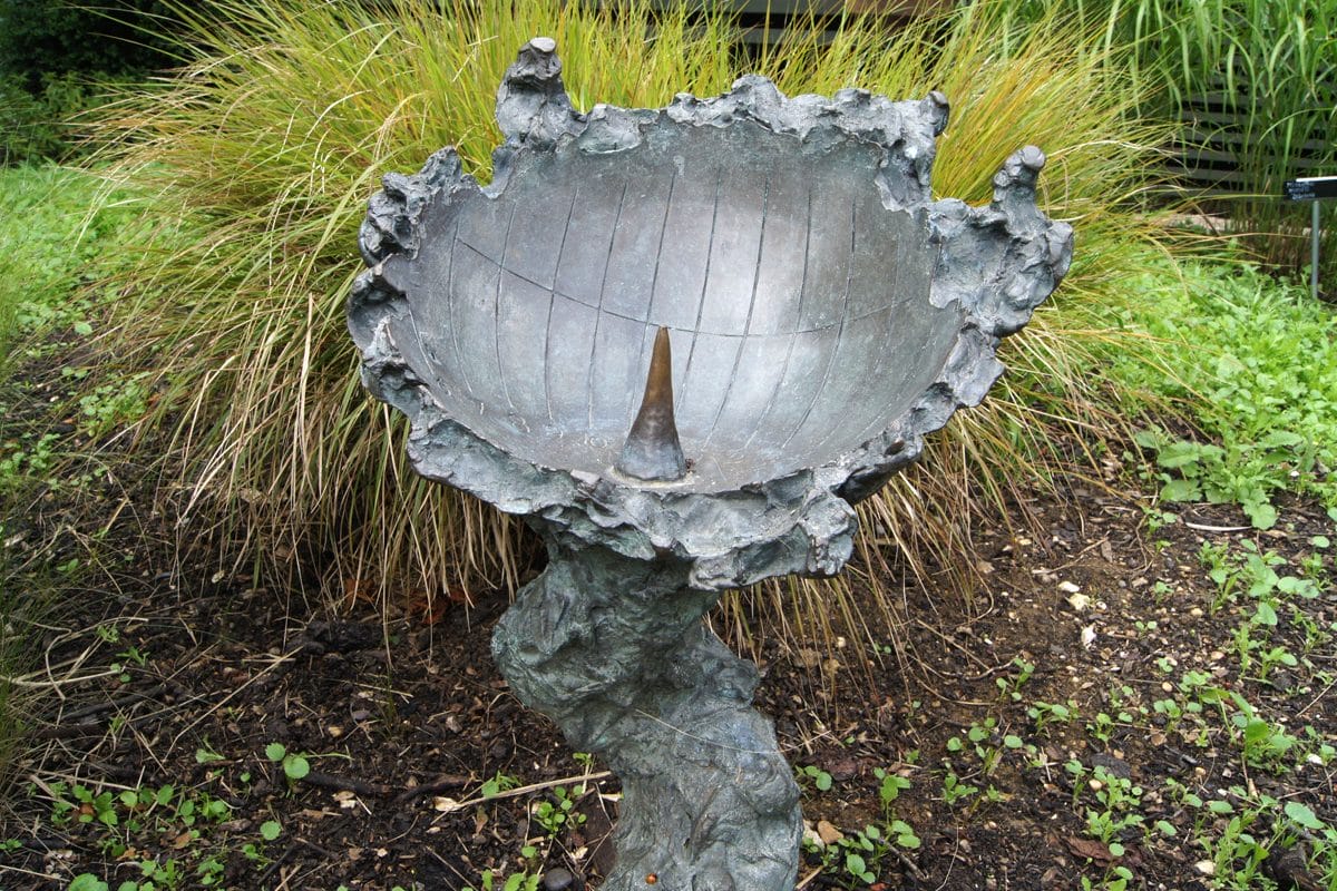 A sculptural bowl in a garden, acting as a sundial