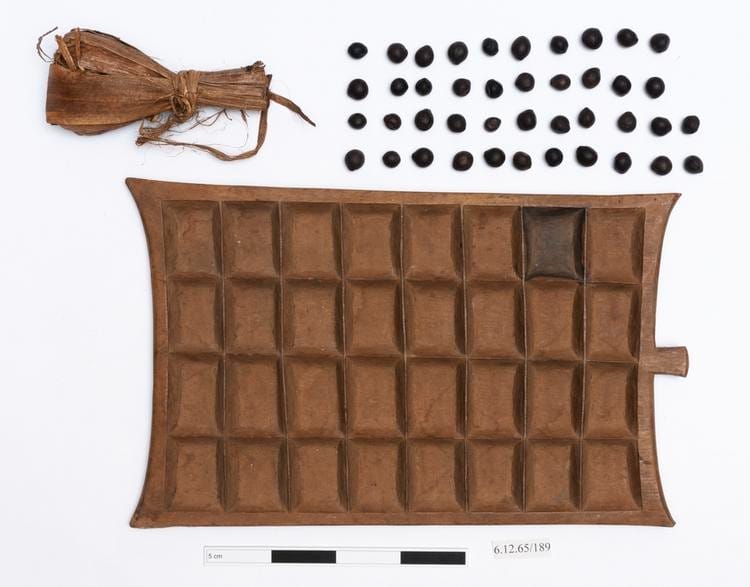 Wooden board game with stones and bag laid out next to it.