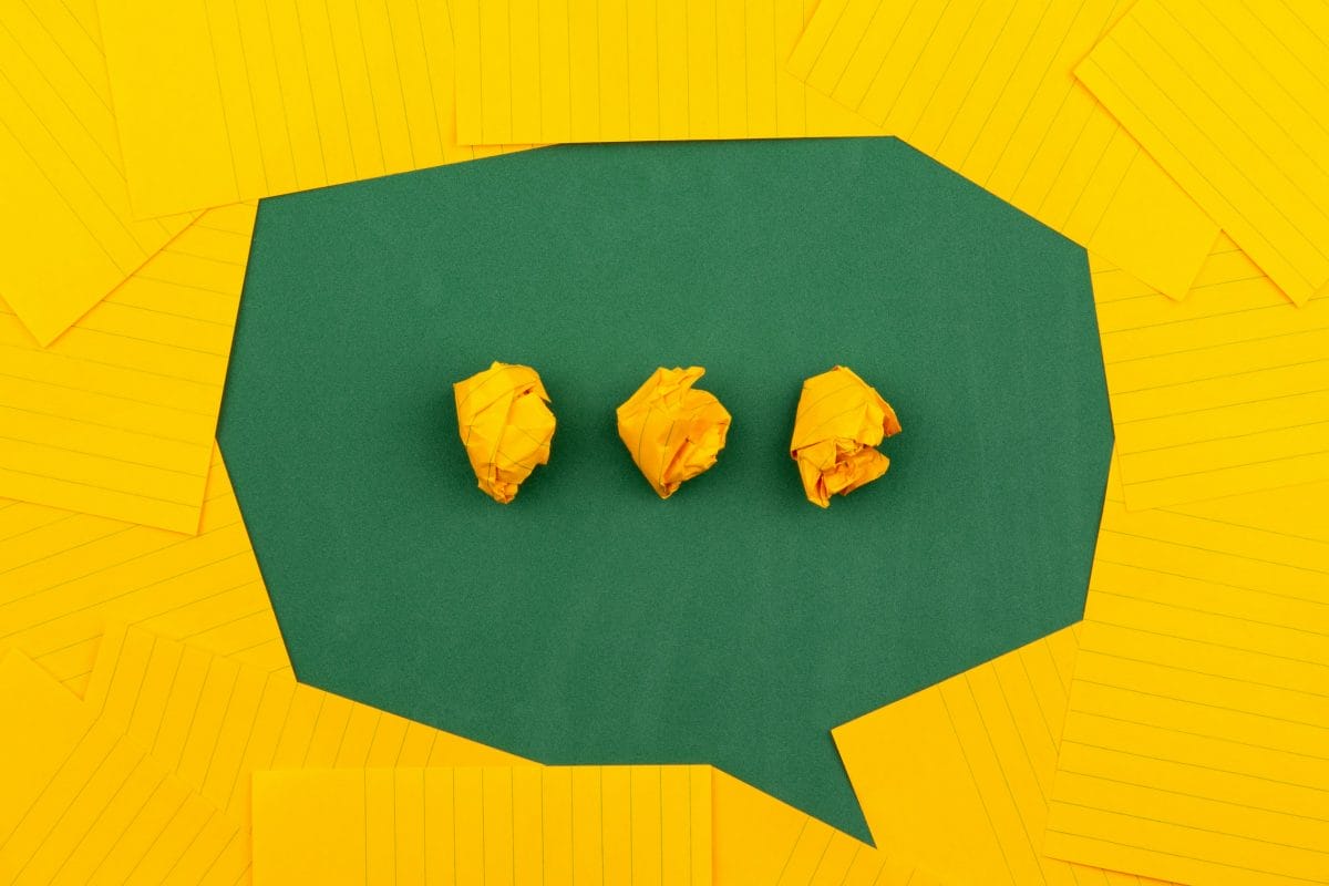 A speech bubble with three dots made of paper