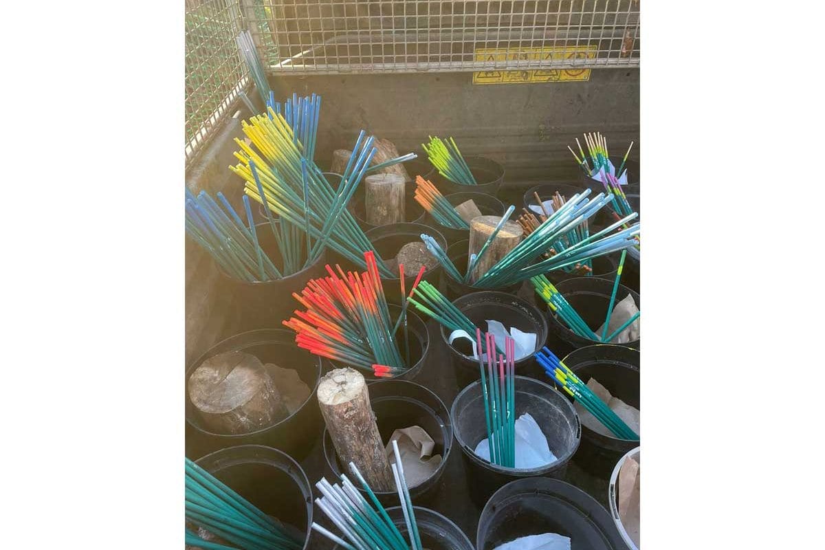 Buckets full of green sticks with different coloured ends