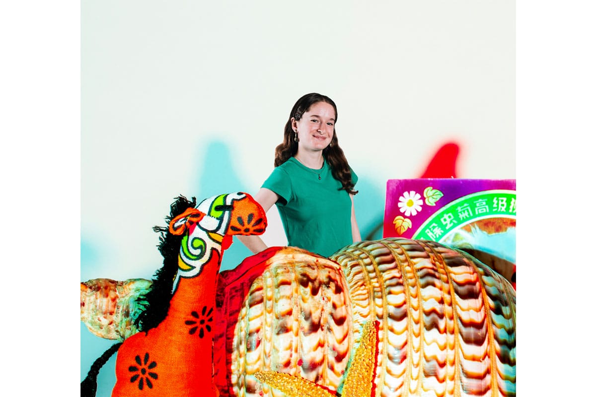 Photo of a young woman edited to look small next to a horse figure and a shell