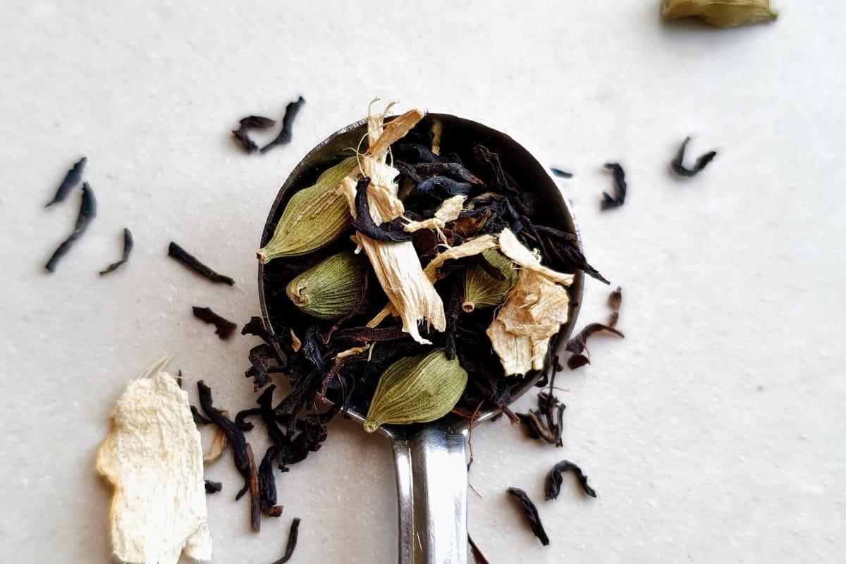 Spoon holding the ingredients for masala chai