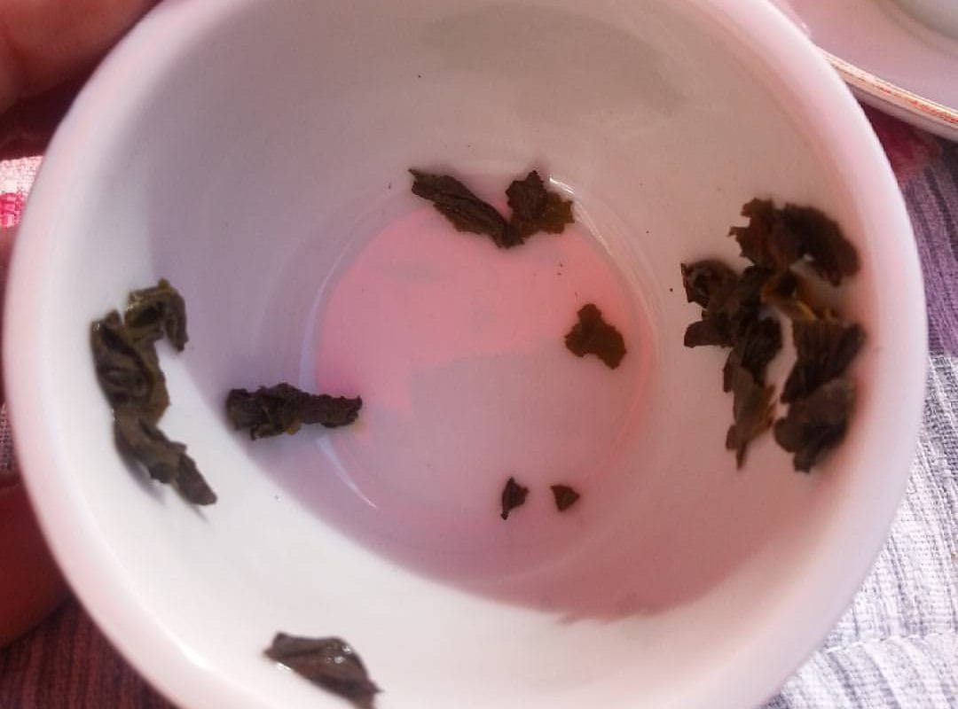 Tea leaves form shapes at the bottom of an empty teacup