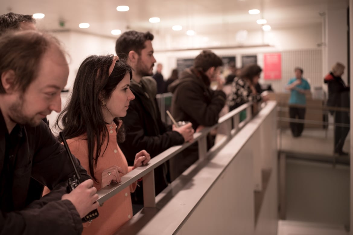 Adults gather at the balcony and look at a display beneath at the Horniman Museum