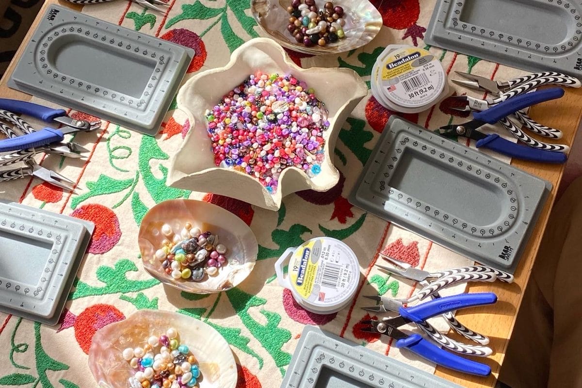 Table set up for a jewellery making workshop, with dishes full of beads in the centre