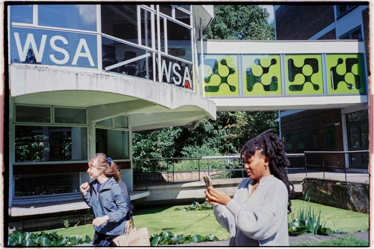 Artist Osaru Obaseki stands outside and looks at her phone