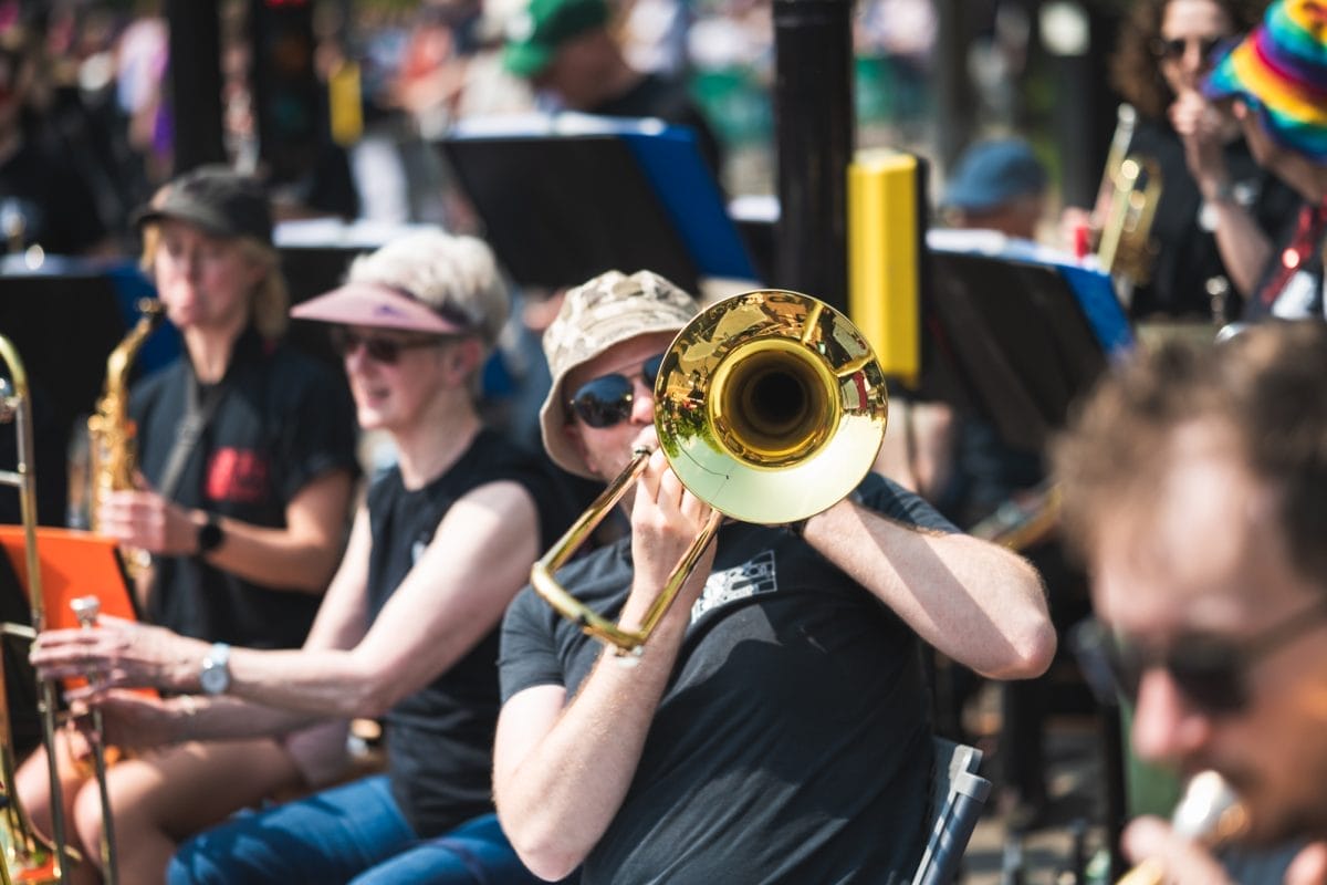 Man plays trumpet with instrument aimed at camera