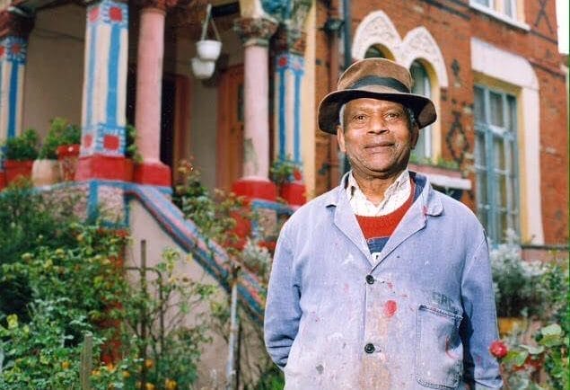 Mr Pink in front of his colourful house