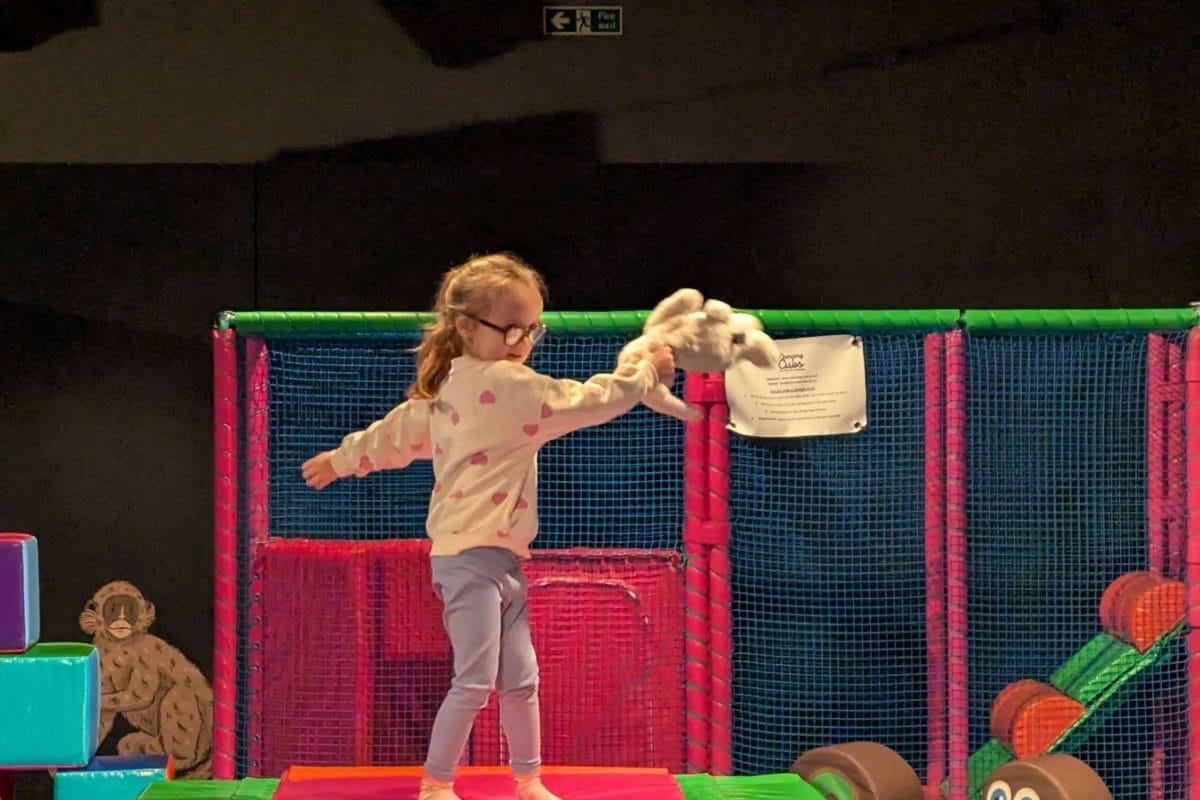 Child stands on soft play equipment