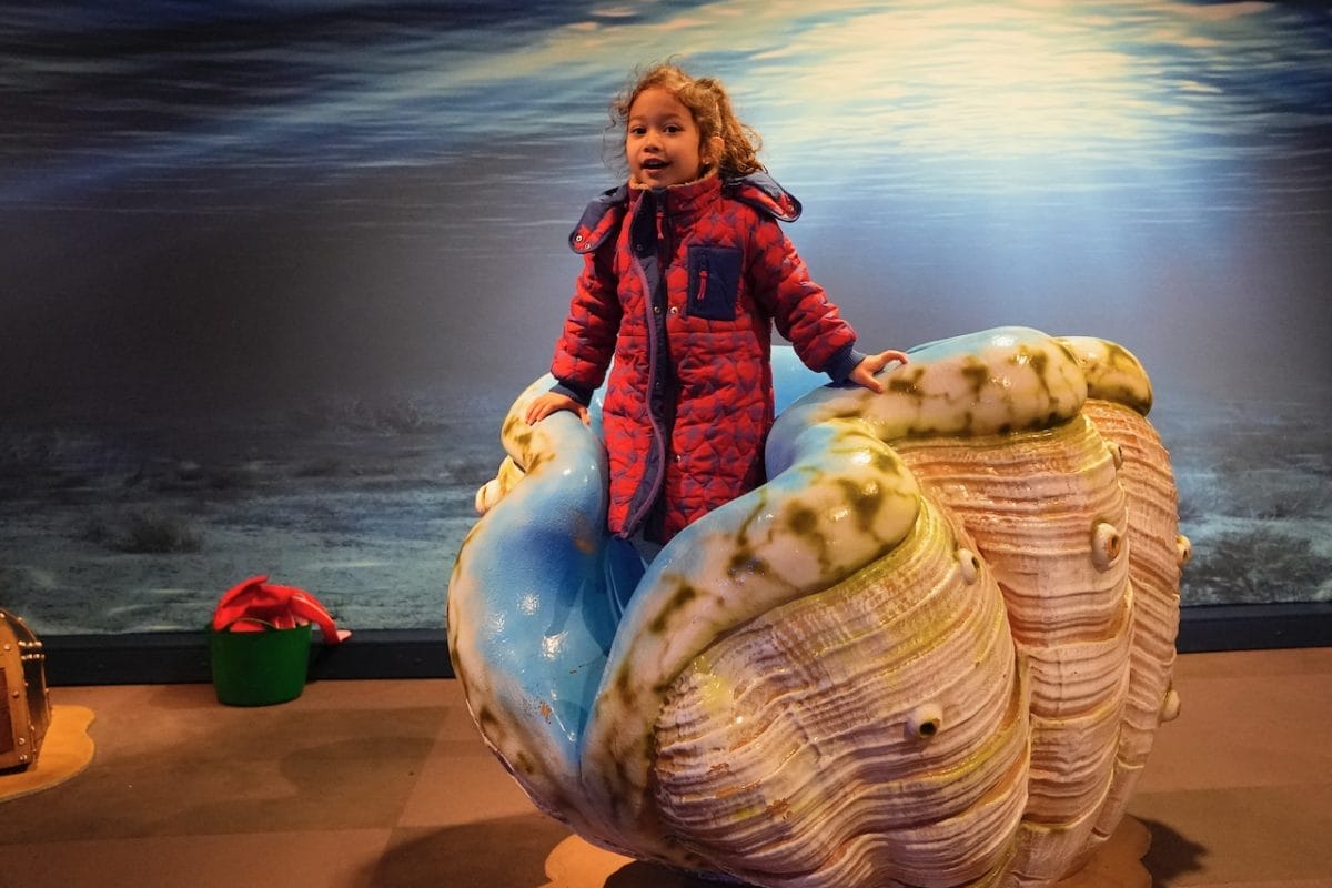 A child emerges from a clam figurine at the Voyage to the Deep exhibition.