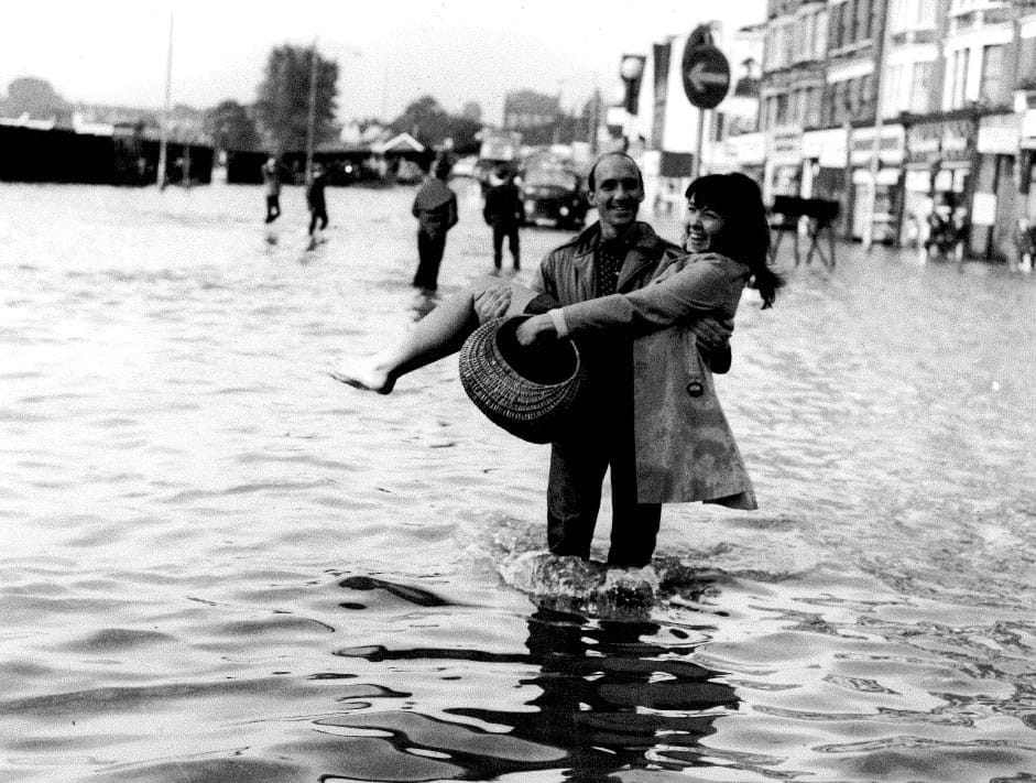 Lady held up from the flood water by man in Lewisham.