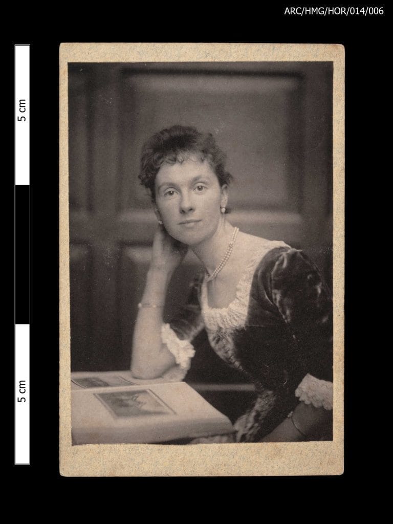 Laura Plomer sitting at a desk and looking at the camera with her head resting on her hand