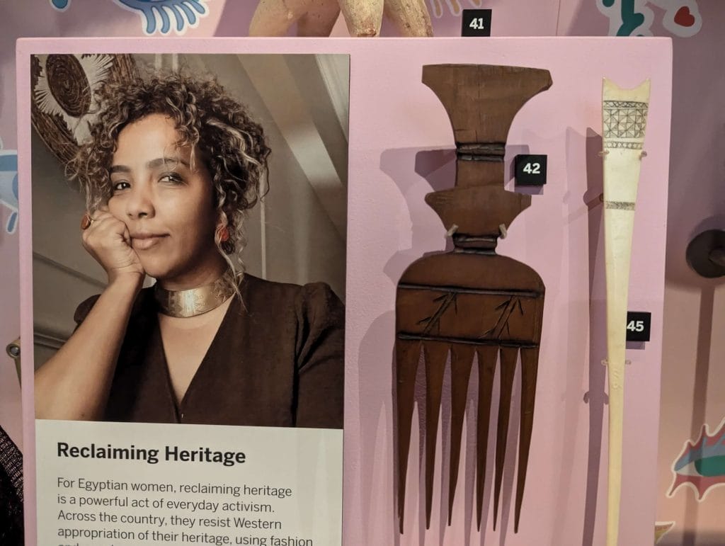 Display case featuring a comb and an image of a woman
