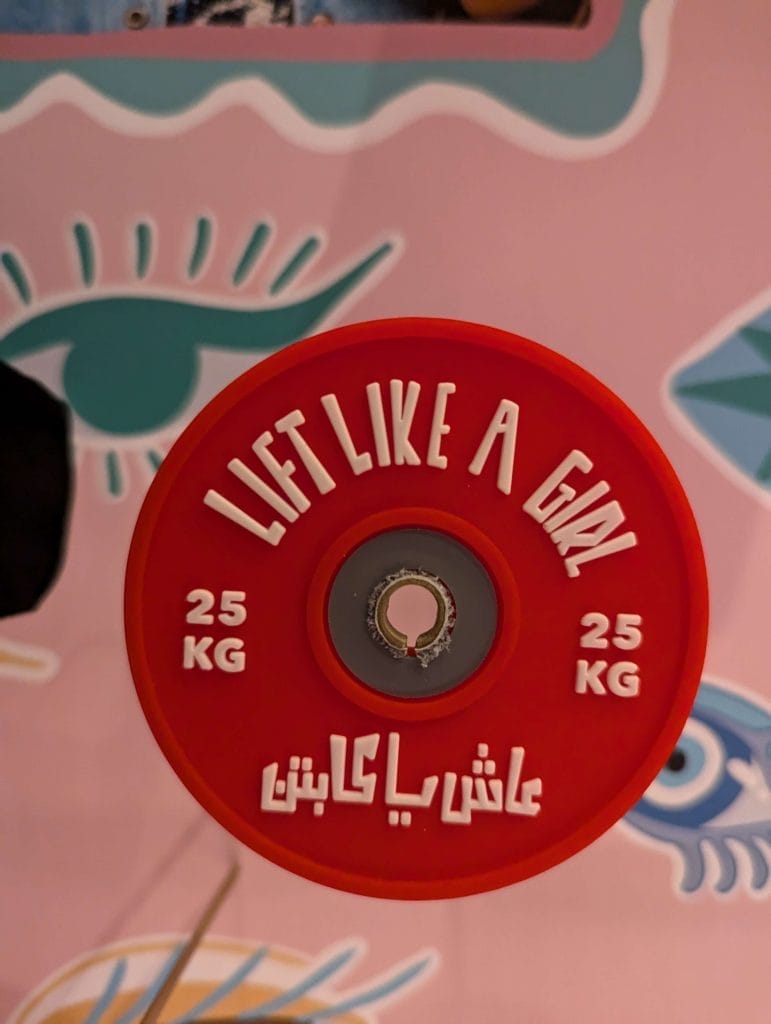 Weight with text on it in english and arabic reading 'lift like a girl'