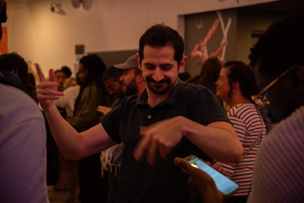 Man dances in a gallery space at an event