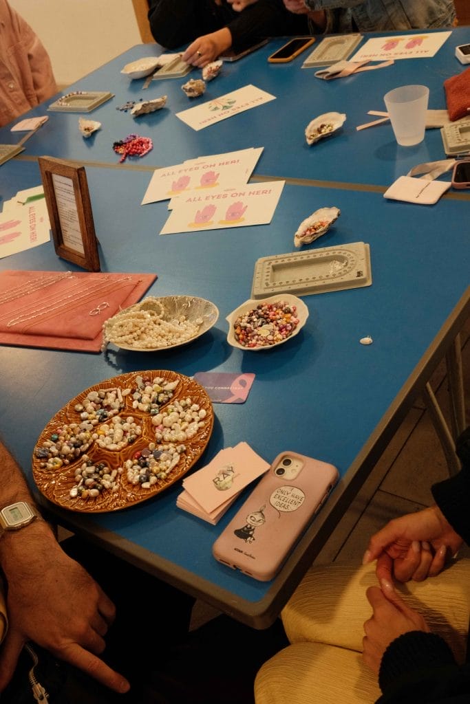 Table adorned with flyers, beads, and craft materials