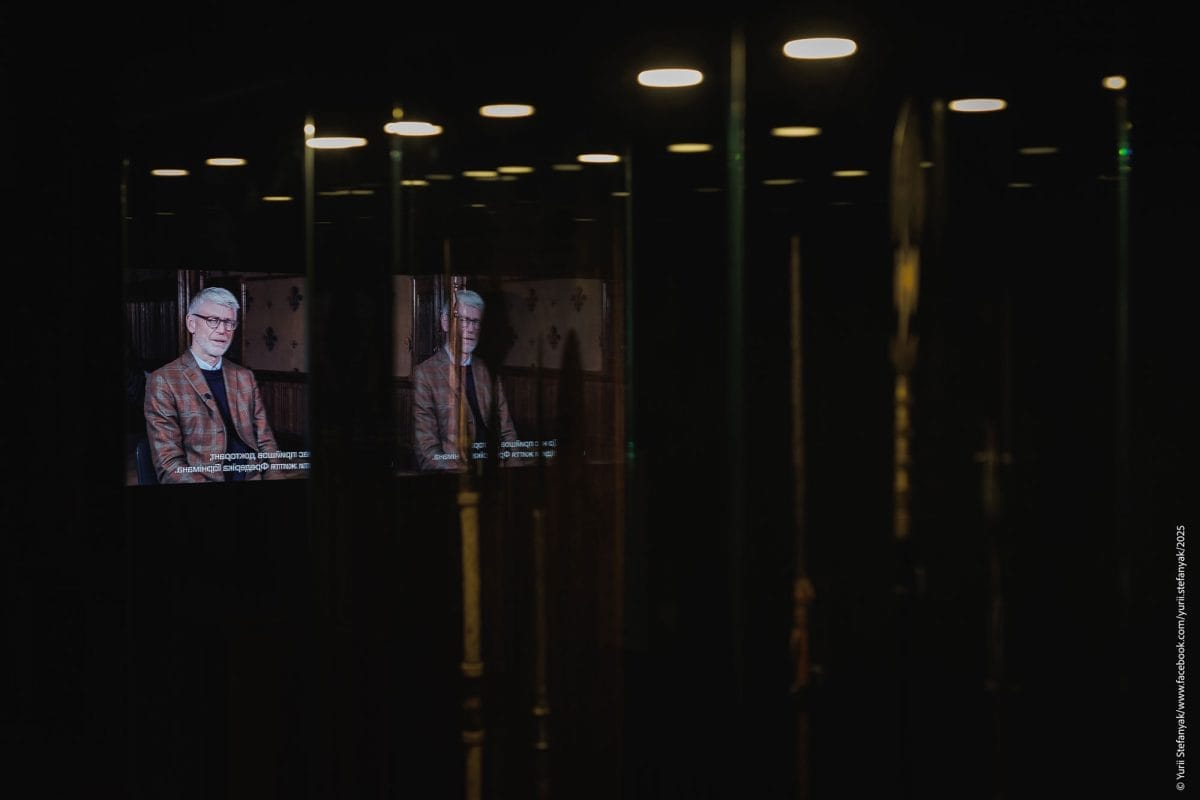 A screen plays in a dark room, with Horniman CEO Gordon Seabright speaking