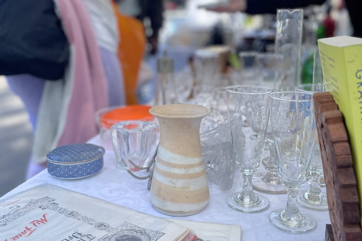 Glass wear and vintage items at the Horniman Second Hand Market, with people out of focus in the background